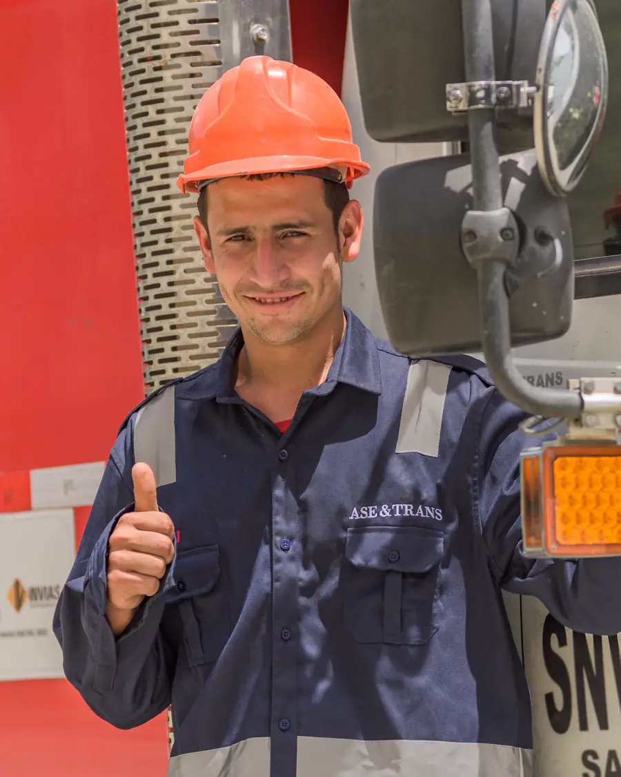 Conductor de ASEYTRANS junto a la cabina de una volqueta roja