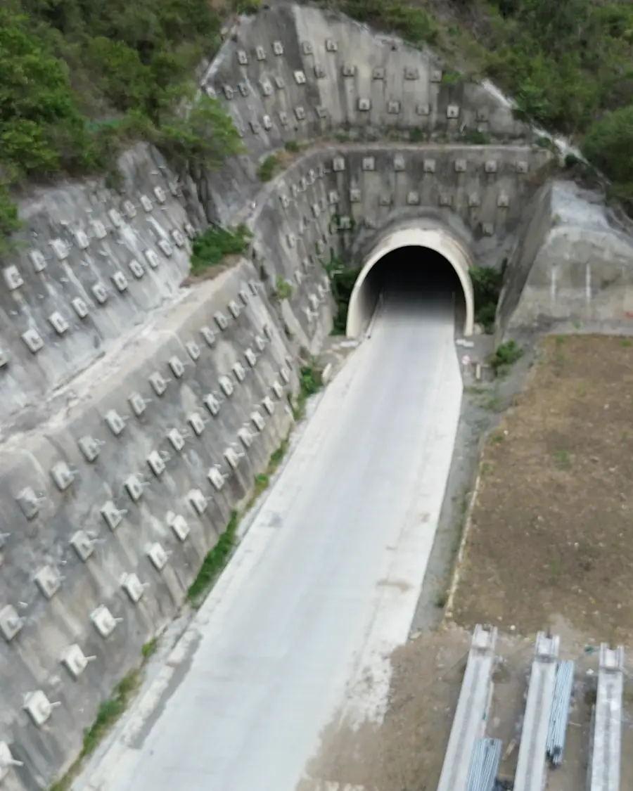 Vista aérea del portal de un túnel vial con muros de contención